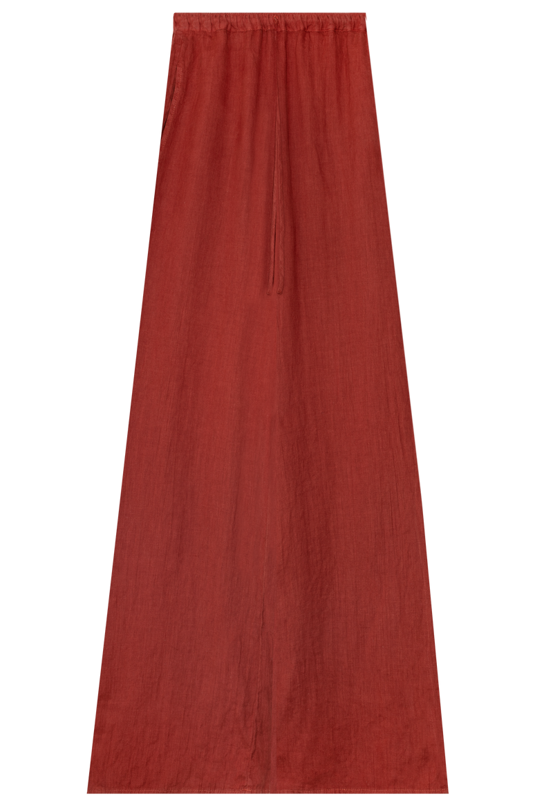 FLATLAY OF A RUST COLORED LINEN DRAWSTRING MAXI SKIRT ON A TRANSPARENT BACKGROUND. 
